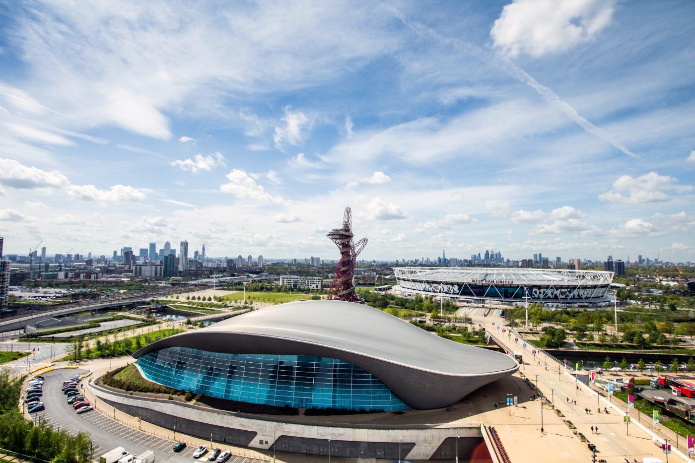 London Aquatics Centre i forgrunnen, med Canary Wharf og City of London på horisonten, sett fra Stratford. London Stadium er forbundet med Stratford via en bro.