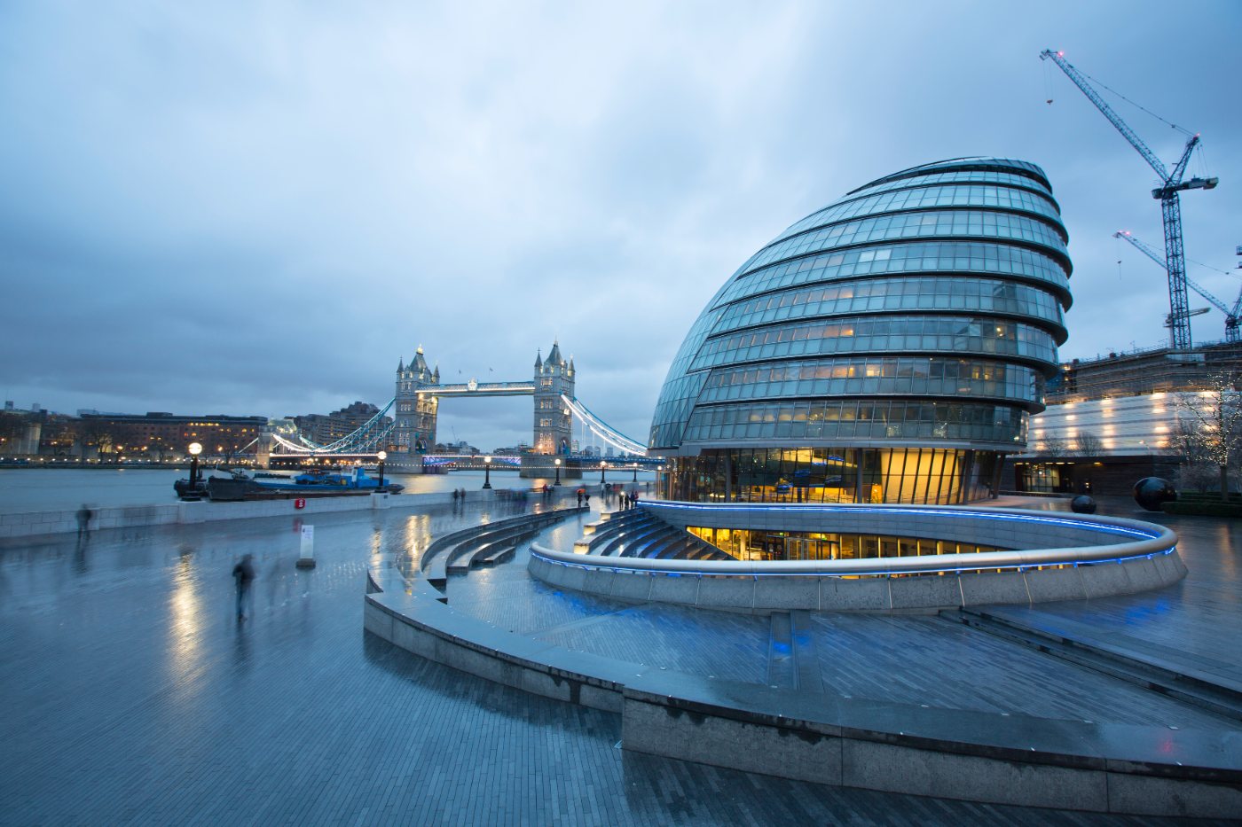 Kveldsscene i London med City Hall og Tower Bridge i bakgrunnen, samt trappene til The Scoop amfiteater i forgrunnen.