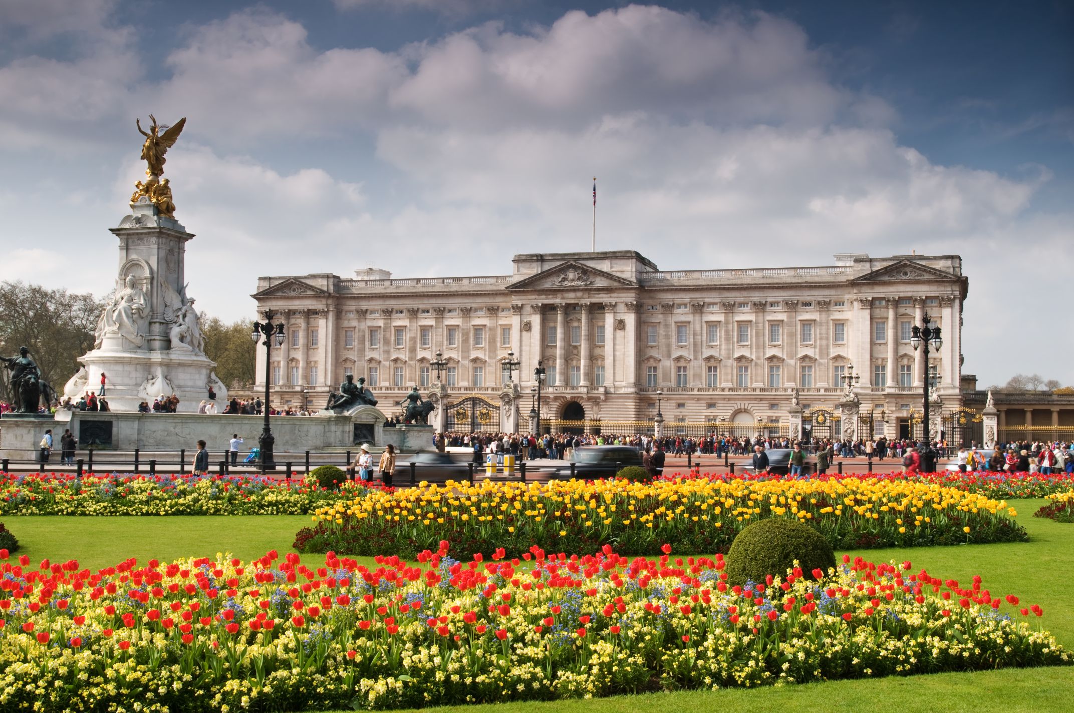 Buckingham Palace med en folkemengde av besøkende om våren.