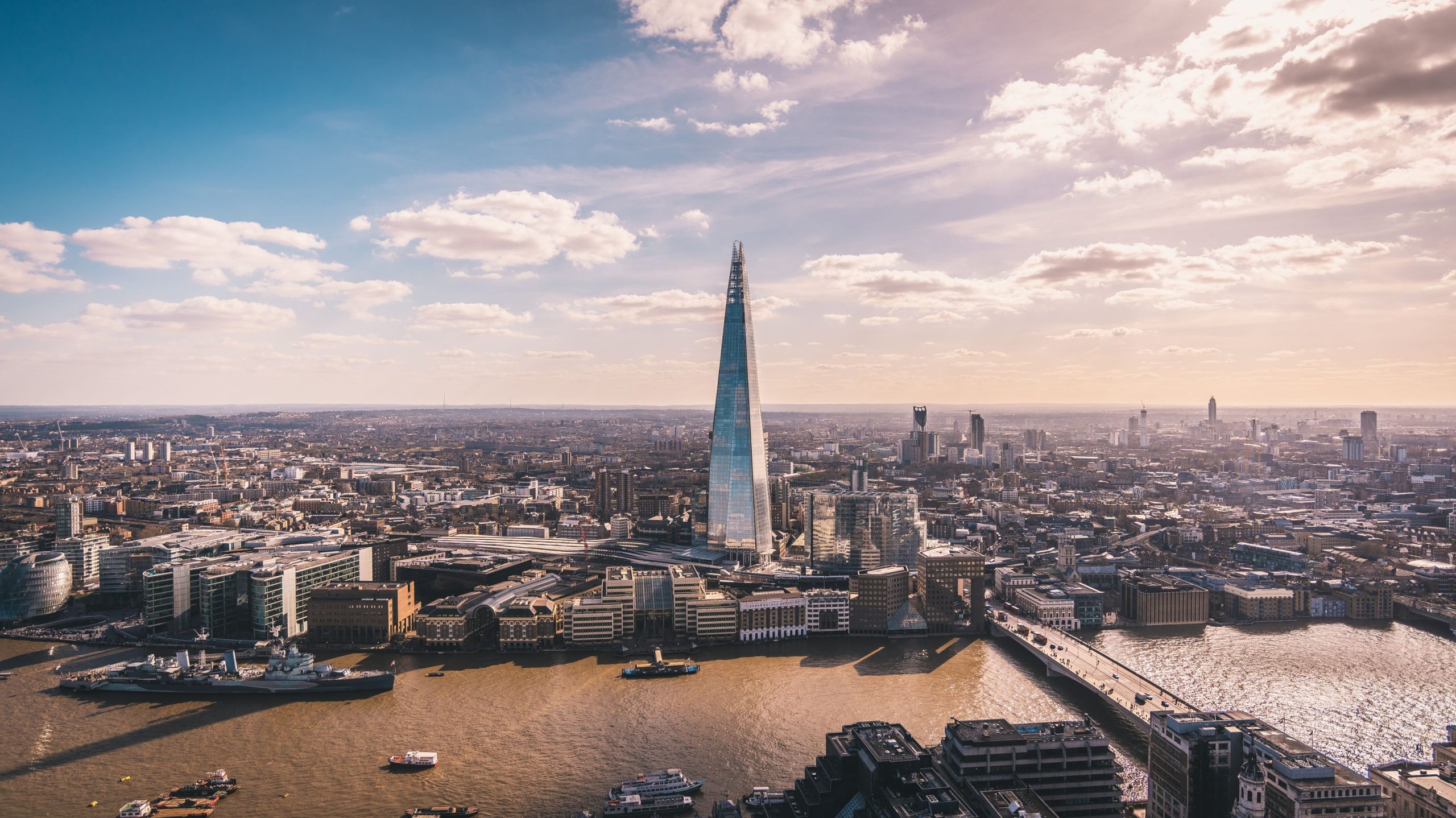 ChatGPT sa: Panoramautsikt over Themsen, The Shard, Londons skyline og bybilde, sett fra en skyskraper. Flyfoto over storbyen.